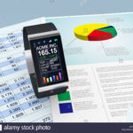 One Smartwatch With A Stock Market Application And Paper Worksheets And Stock Market Worksheets